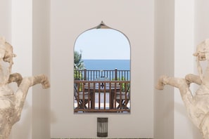 Enjoy a serene view from the arched window, overlooking a balcony with a table and chairs.