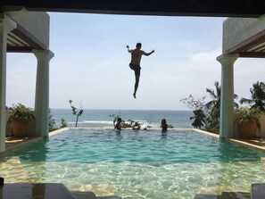 An infinity pool with clear water and a view of the ocean.