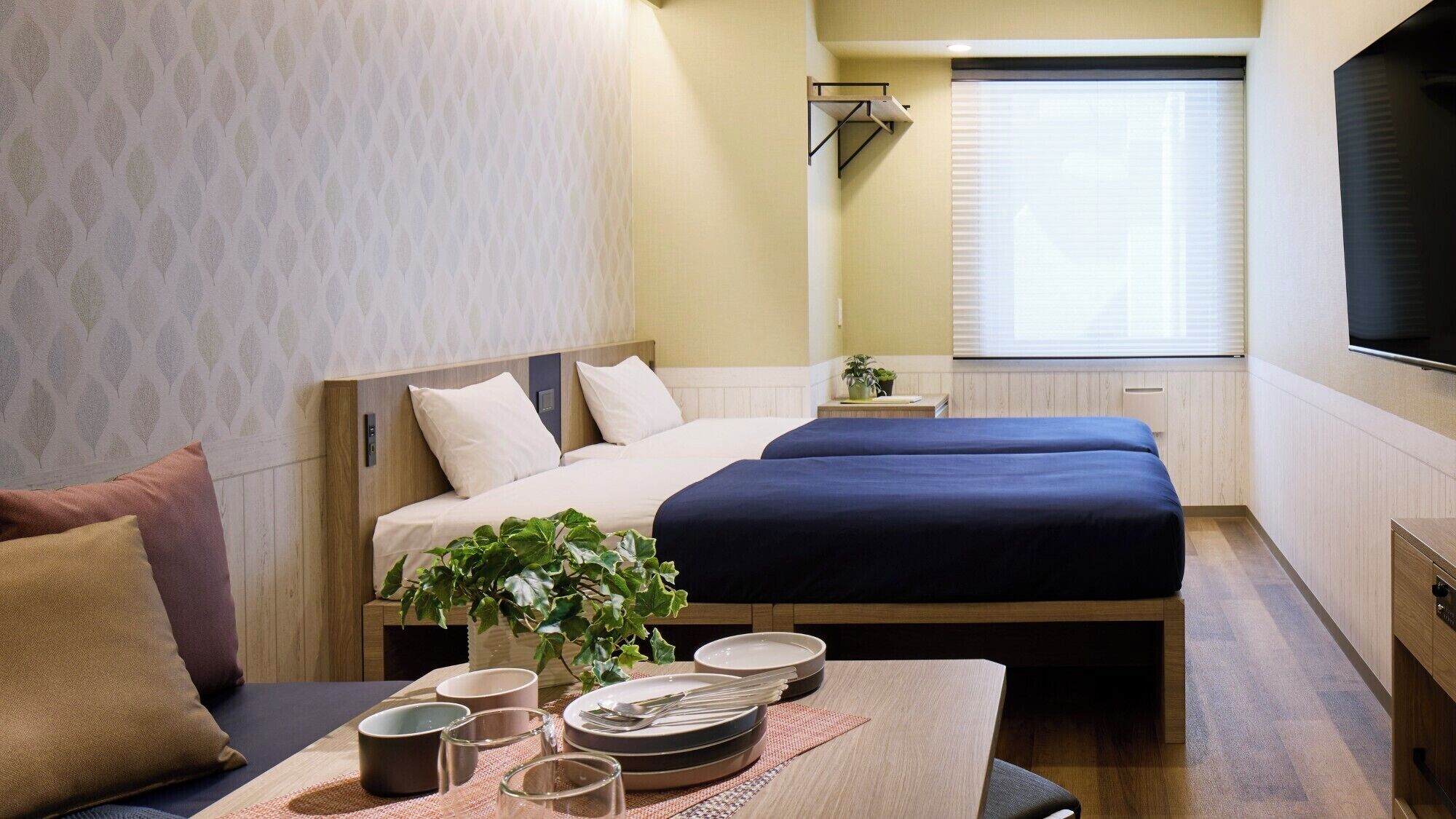 Una habitación de hotel con cama, mesita de noche y televisión.