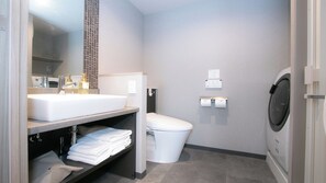 Ein modernes Badezimmer mit Waschbecken, Toilette und Waschmaschine.