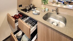 A modern kitchen with a built-in stove, a stainless steel sink, and a wooden cabinet with a pull-out drawer. - Minn Ueno Shin-Okachimachi (Tokyo)