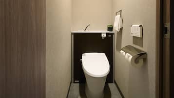 Ein kleines, modernes Badezimmer mit Toilette, Waschbecken und Handtuchhalter.