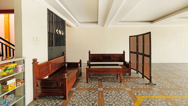Una habitación con un banco de madera, una mesita y un estante con aperitivos.