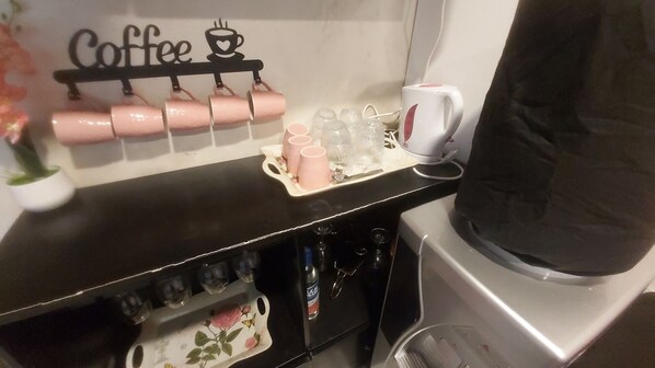 A coffee station with a coffee cup holder, a coffee machine, and a coffee pot.