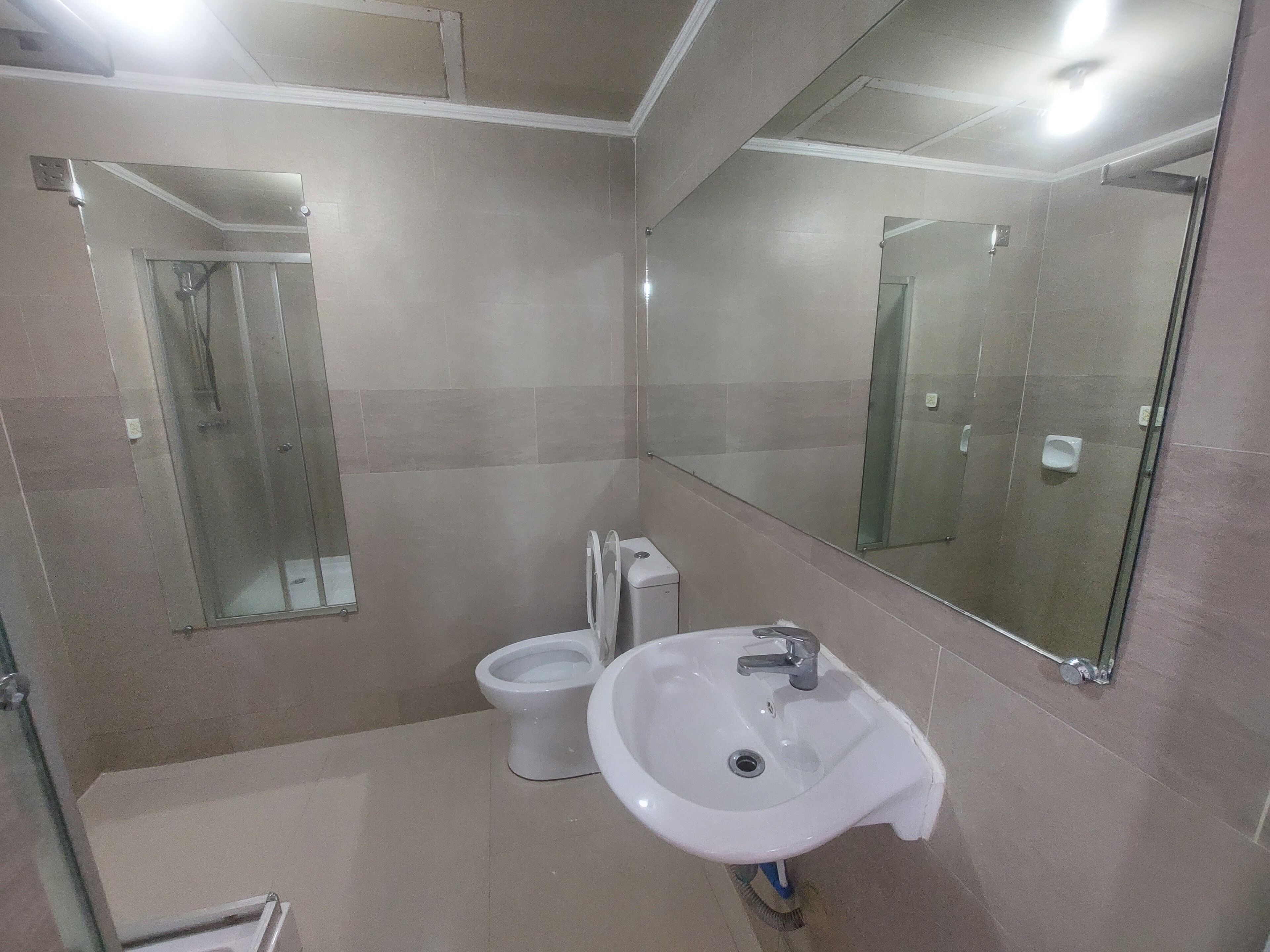 Un baño con inodoro, lavabo y cabina de ducha de vidrio.