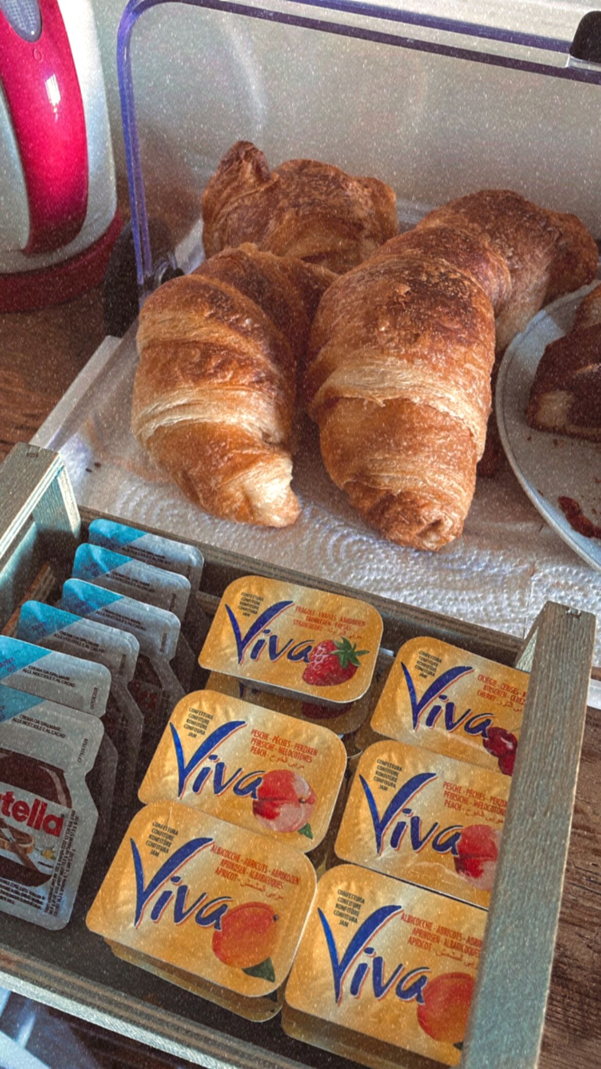 A display case with croissants and Viva fruit yogurt containers.