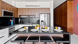Una cocina moderna con una isla central, electrodomésticos integrados y una zona para desayunar.
