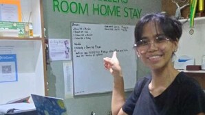 A room with a desk, a laptop, and a red bag. There is a sign on the wall that reads "Angel Travellers Room Home Stay". - ANGEL ROOM HOMESTAY AT KASSEL RESIDENCES (Parañaque)