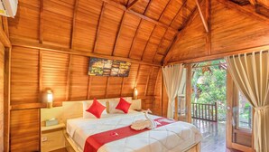 Dormitorio con paneles de madera, una cama, mesitas de noche y vistas al exterior.