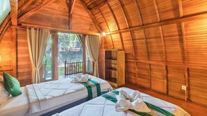 Una cabaña de madera con dos camas, un balcón y techo de madera.