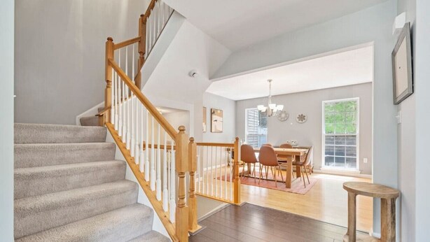 A staircase with wooden railings leading to a dining area with a table and chairs. - NEW! 3 Bdrm | Mt Washington | Garage (Pittsburgh)