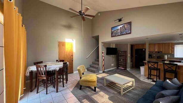 A spacious living room with a dining area, a sofa, a coffee table, and a kitchen in the background. - *Sunland Estates* Stunning property (Quincy)