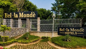 A sign for Bel-la Mondè Hotels with a stone wall and metal gate. - Bel-La Monde Hotel NH8 at 6km from IGI Airport Delhi (New Delhi)