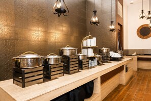Una mesa de buffet con diferentes recipientes de comida y utensilios para servir.