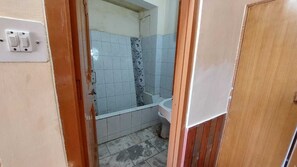 Un bagno con doccia, WC e lavandino.