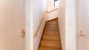 A wooden staircase with a handrail, white walls, and a small window at the top. - Minamiaoyama 1st (Tokyo)