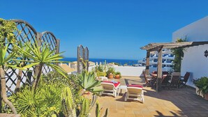 A patio with outdoor furniture, a pergola, and potted plants. - Apartment 'La Terraza del Mar' with Sea View, Wi-Fi and Air Conditioning (Manilva)