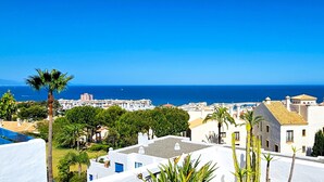 A coastal town with white buildings, palm trees, and a view of the sea. - Apartment 'La Terraza del Mar' with Sea View, Wi-Fi and Air Conditioning (Manilva)