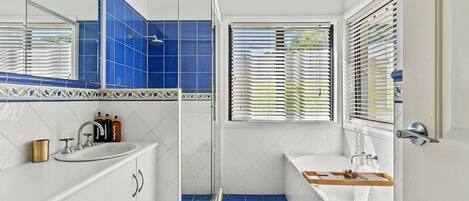 A bathroom with a shower, sink, and bathtub.
