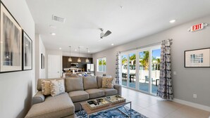A modern living room with a sofa, coffee table, and a view of the outdoor patio.