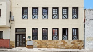 En byggnad med en skylt som visar ”STADSCENTRUM”, många fönster med korsposter och en grund av sten.