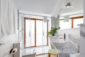 A modern bathroom with a glass shower enclosure, a bathtub, and a sink. - Angeles 6- Giralda Luxury by Valcambre (Seville)