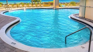 En pool med en dybdemarkering på 8 fod, omgivet af liggestole og udsigt til havet.