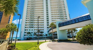 A high-rise hotel with a modern design, featuring a prominent entrance and a covered walkway. - OCEAN STAR SUITE @Celadon Beach Resort-OCEANFRONT (Panama City Beach)