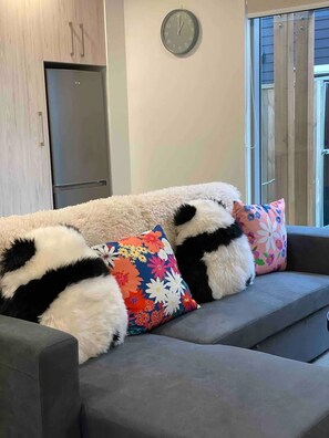 A grey sofa with black and white patterned cushions and a floral pillow. - Inner City Luxury 2 Bedroom CBD Townhouse (Christchurch)