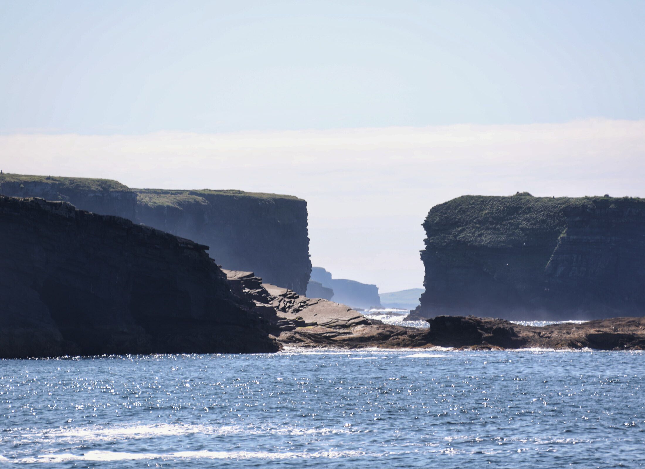A coastal landscape with cliffs and a body of water.