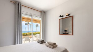 Una habitación de hotel con una cama, un espejo y vista a la playa.