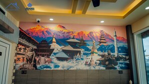 A hotel lobby with a mural of Asian architecture and mountains. - Hotel Happy Home (Siddharthanagar)