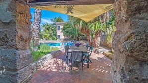 A patio with a pool, stone walls, and outdoor furniture. - 600 meters away from the sea, private pool, lush garden (Carini)