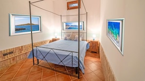 A four-poster bed with a view of the sea, framed pictures on the walls, and a tiled floor. - 600 meters away from the sea, private pool, lush garden (Carini)