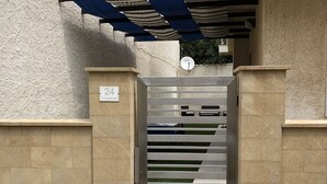 A gated entrance with a metal gate, beige stone walls, and a satellite dish. - 2 Bedroom Villa in Calabernardo (Calabernardo)