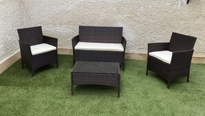 A set of three wicker chairs with white cushions, arranged on artificial grass against a textured wall. - 2 Bedroom Villa in Calabernardo (Calabernardo)
