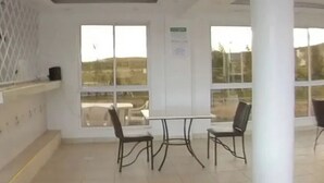 Ein geräumiges Zimmer mit großem Fenster, einem Tisch und zwei Stühlen.