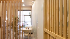 Un couloir avec une cloison en bois et une table ronde à l’arrière-plan.