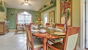 A dining room with a wooden table set for six, surrounded by patterned chairs. - Naples Home w/ Pool, Extended Stays Welcome! (Naples)