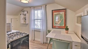A compact kitchen with a gas stove, a refrigerator, and a dining table with chairs. - Spacious Lexington Studio: 2 Miles to Rupp Arena (Lexington)