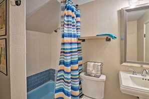 A bathroom with a striped shower curtain, a white sink, and a mirror. - Spacious Lexington Studio: 2 Miles to Rupp Arena (Lexington)