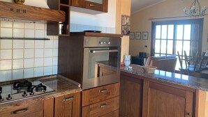 A kitchen with wooden cabinets, a stainless steel oven, and a gas stove.