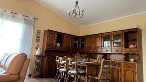 A dining area with wooden cabinets, a chandelier, and a dining table with chairs.