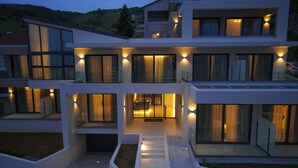 Een modern meerlaags huis met grote ramen en een goed verlichte entree.
