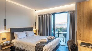 Een moderne hotelkamer met een groot bed, een bureau en uitzicht op de stad.
