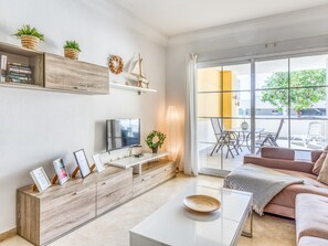 Una sala de estar moderna con televisor, mueble de madera y sofá.