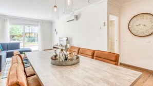 A spacious dining area with a long wooden table, leather chairs, and pendant lighting. - Modern apartment in Estepona, ground floor with terrace and pool, close to port and beach (Estepona)