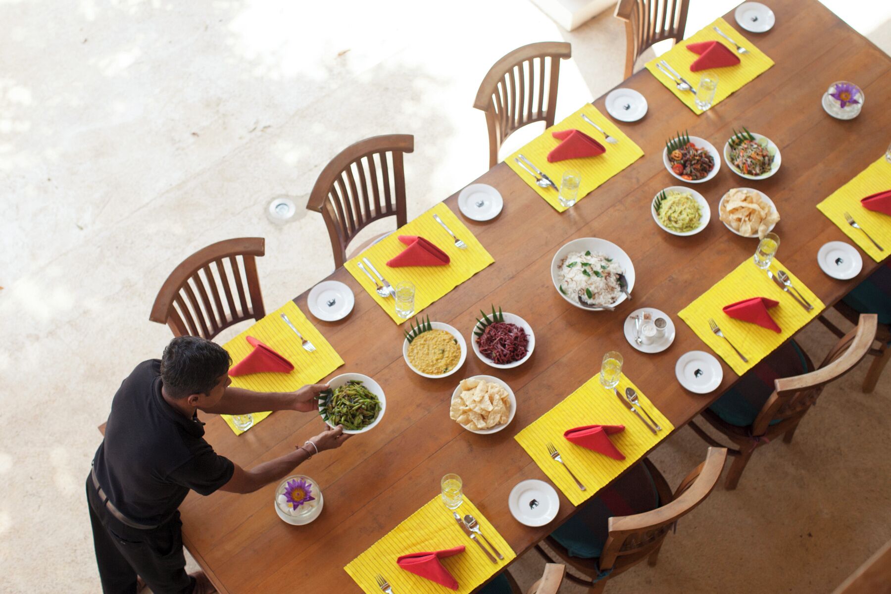 A dining table set with multiple dishes, utensils, and napkins.