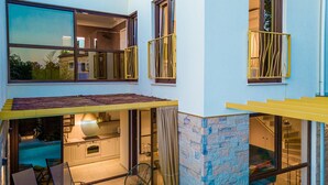 A two-story house with a swimming pool, outdoor seating, and a kitchen visible through glass doors. - Villa Nascosta with Private Pool, Sauna and en-suite bathrooms (Vodnjan)