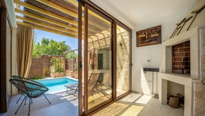 A modern patio with a pool, sliding glass doors, and a fireplace. - Villa Nascosta with Private Pool, Sauna and en-suite bathrooms (Vodnjan)